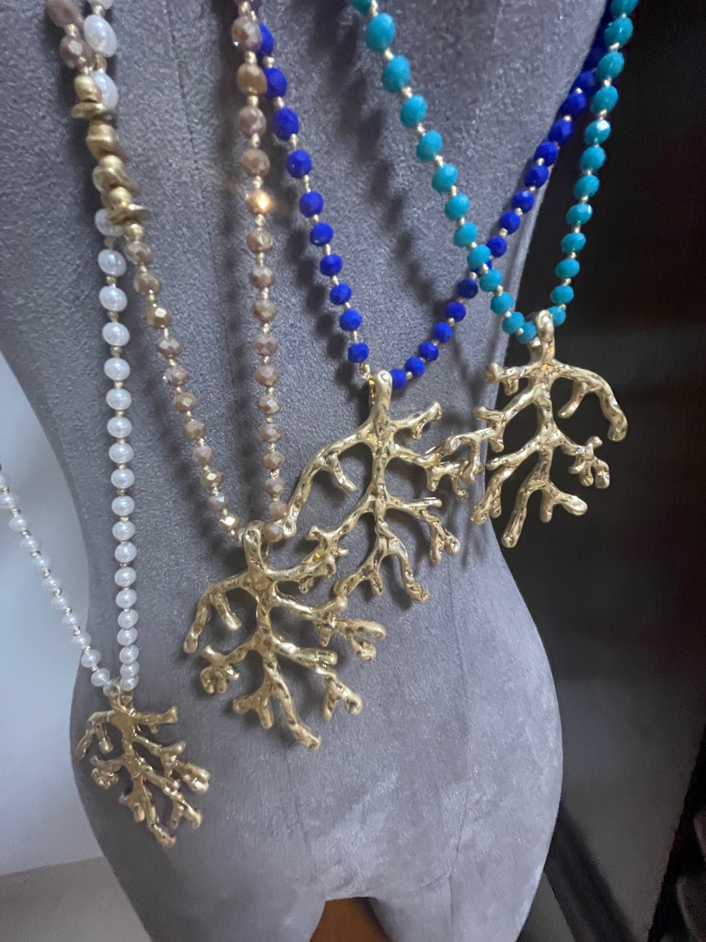 Long beaded and gold pendant with coral design piece